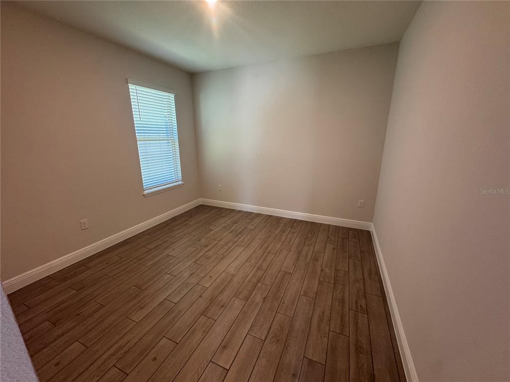 A modern kitchen features white cabinetry, stainless steel appliances, a farmhouse sink, and quartz countertops — 11857 SHINE VIEW LANE, WINTER GARDEN, FL