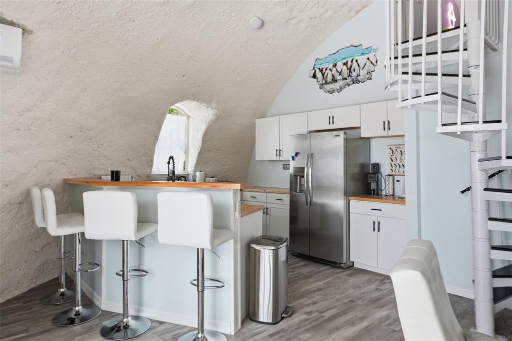 A kitchen with white cabinets, stainless steel appliances, and a breakfast bar under a dome — 7570 E RINGER COURT, INVERNESS, FL