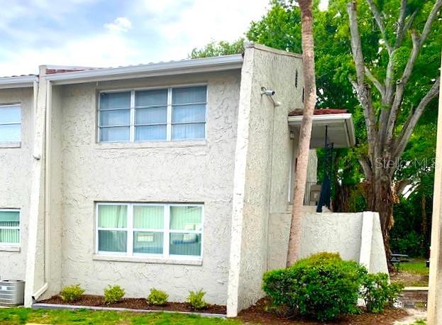 A parking lot sits in front of a multi-story apartment building near a lake — 1103 CYPRESS GARDENS BOULEVARD UNIT 13, WINTER HAVEN, FL