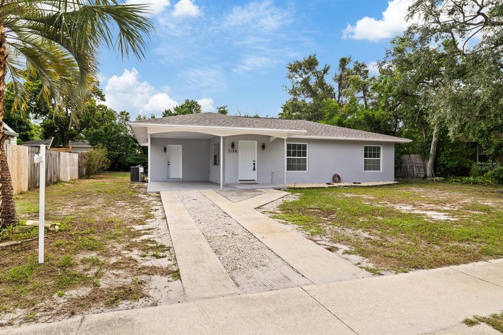 A modern kitchen features white cabinets, stainless steel appliances, and a black and white backsplash — 7156 SPRING HILL DRIVE, SPRING HILL, FL