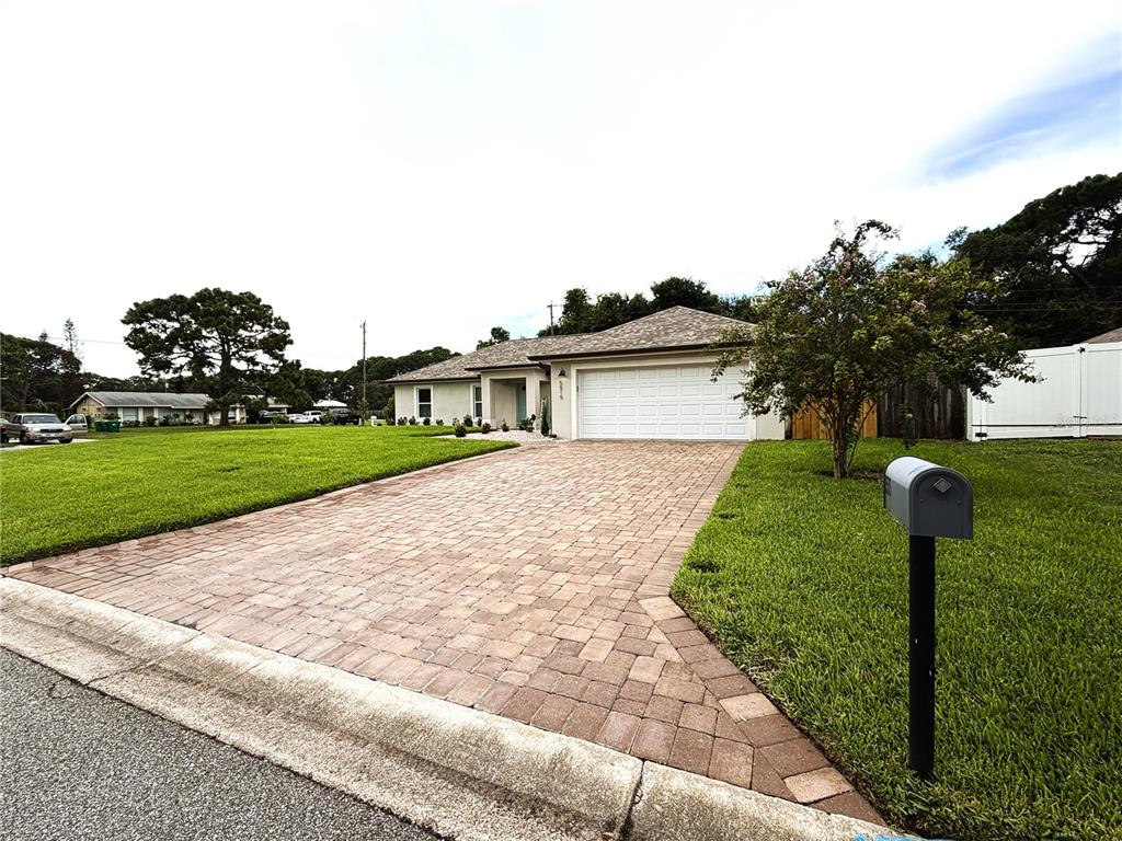 A single-story house with a paved driveway, a two-car garage, and a front lawn — 5515 EAGLE WAY, MERRITT ISLAND, FL