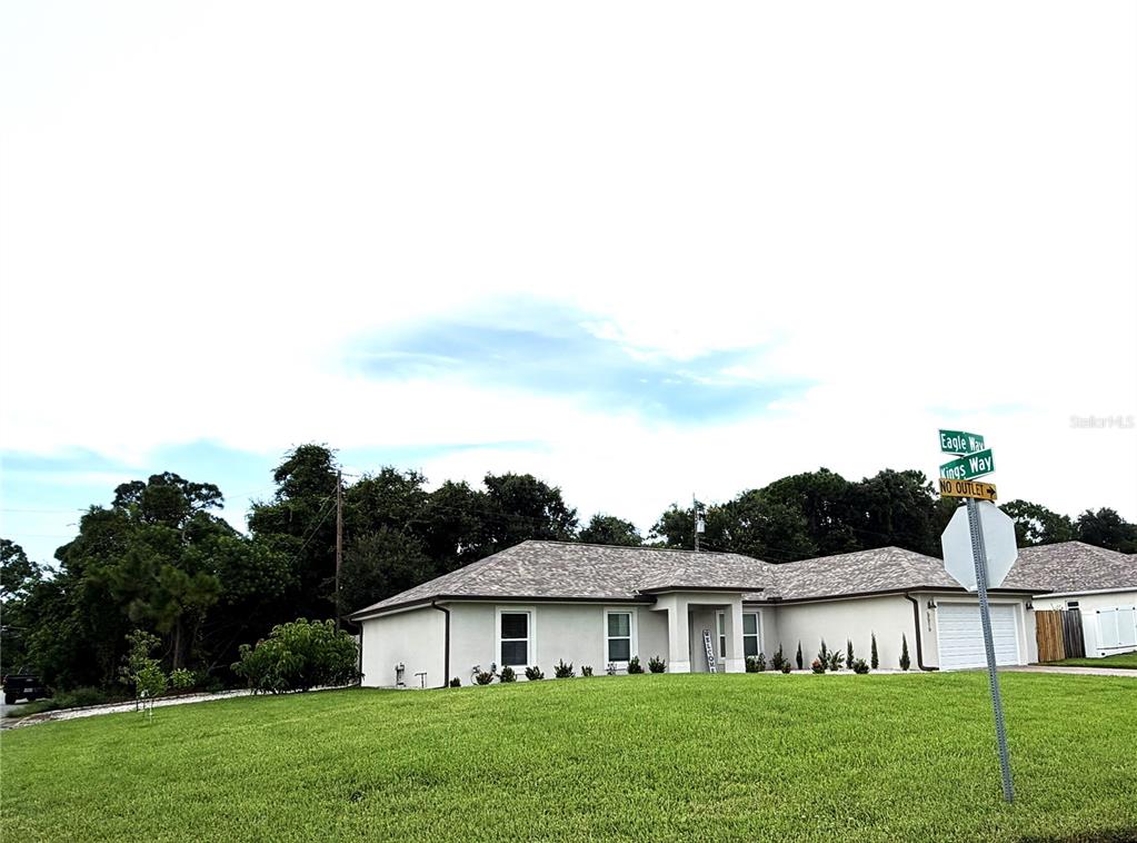 A single-story house with a light-colored exterior and a shingled roof sits on a lawn — 5515 EAGLE WAY, MERRITT ISLAND, FL