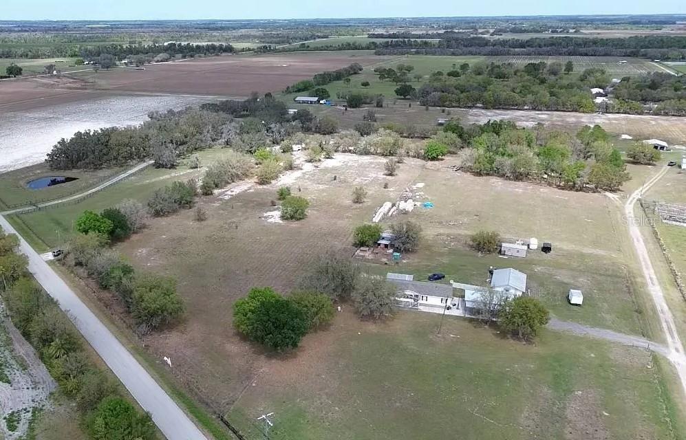 An aerial view shows a rural property with a house, outbuildings, and surrounding pasture land — 30620 TAYLOR GRADE ROAD, DUETTE, FL