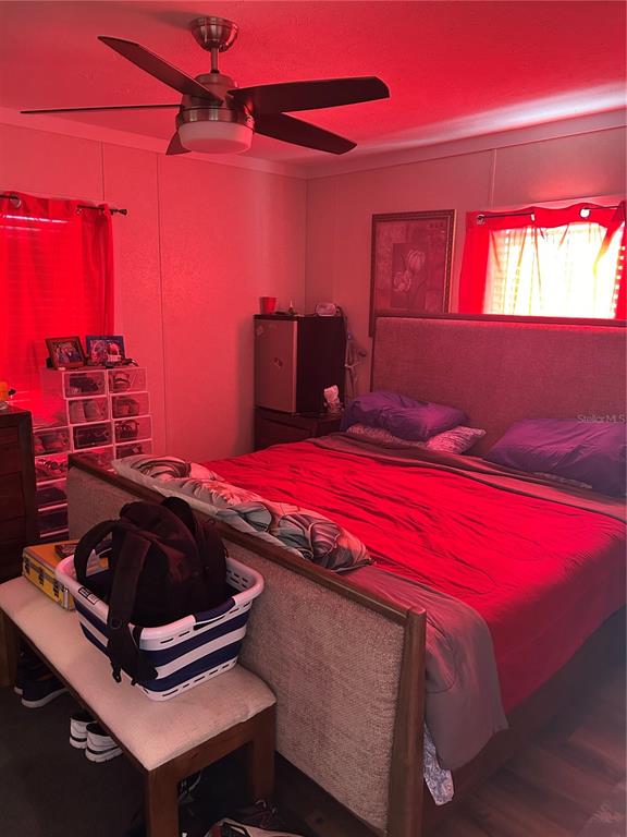 A bedroom features a bed with a headboard, a ceiling fan, and red lighting — 231 TANGLEWOOD DRIVE, APOPKA, FL