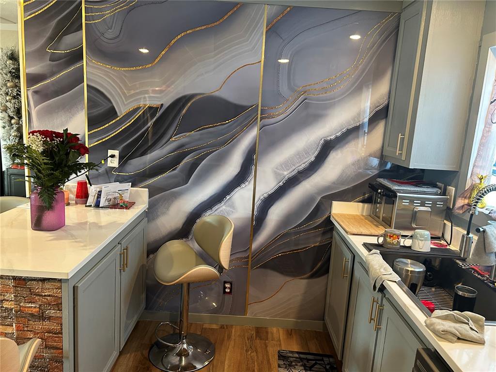 A kitchen features grey cabinets, white countertops, and a large, decorative agate-patterned wall panel — 231 TANGLEWOOD DRIVE, APOPKA, FL