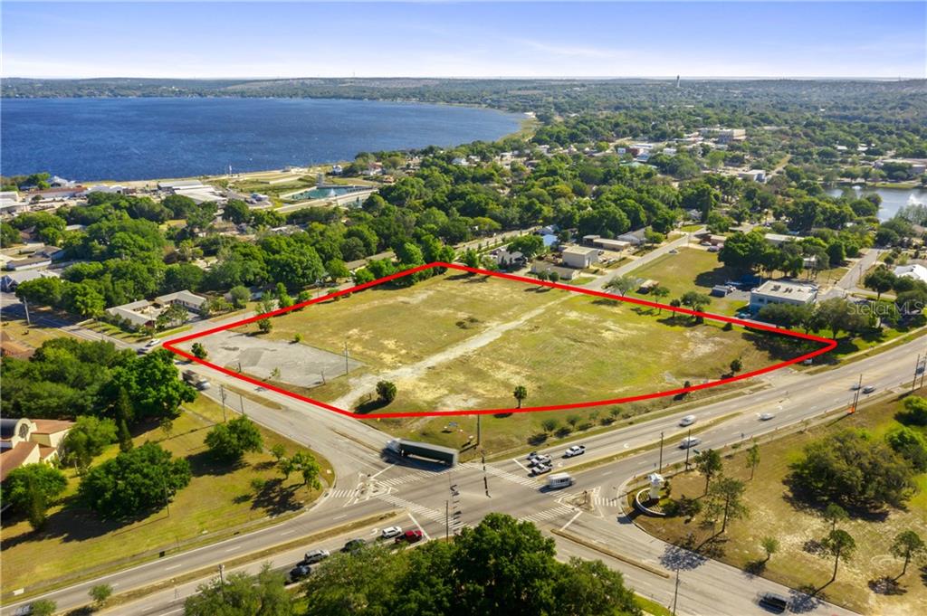 An aerial view shows a large, vacant rectangular lot outlined in red near a lake — 901 12TH STREET, CLERMONT, FL