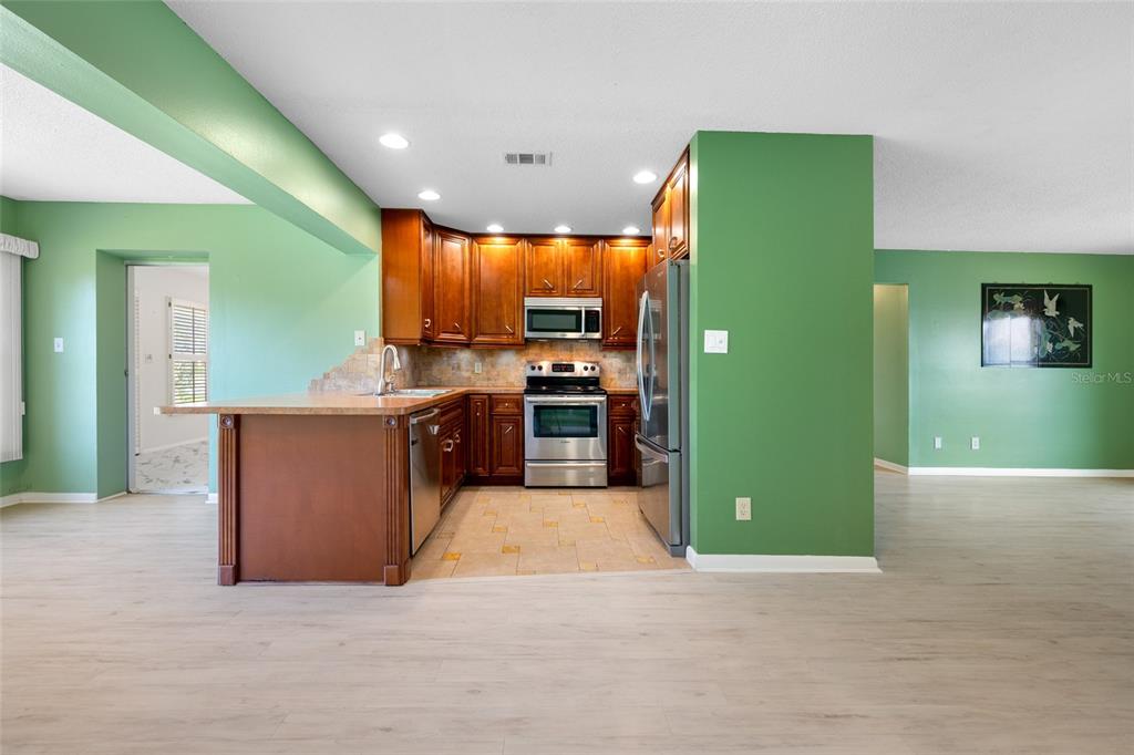 A kitchen with wood cabinets, stainless steel appliances, and green walls — 8440 BRENTWOOD ROAD UNIT 8440, SEMINOLE, FL
