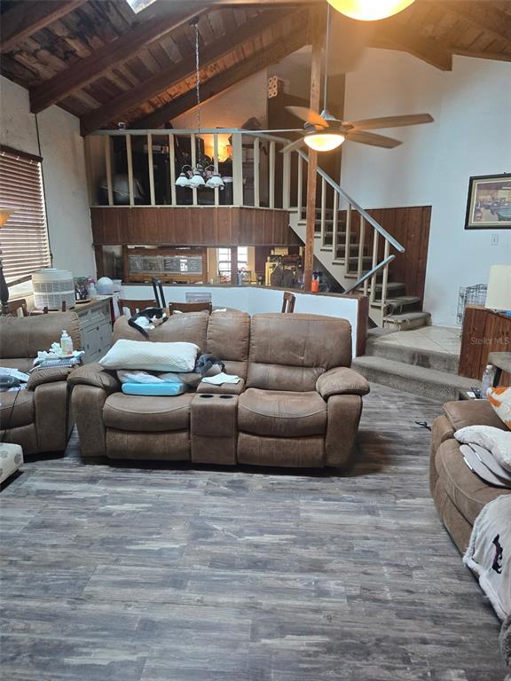 A living room features a brown reclining sofa, vaulted wood-beam ceilings, and an elevated loft area — 11069 NE 14TH AVENUE, BRANFORD, FL