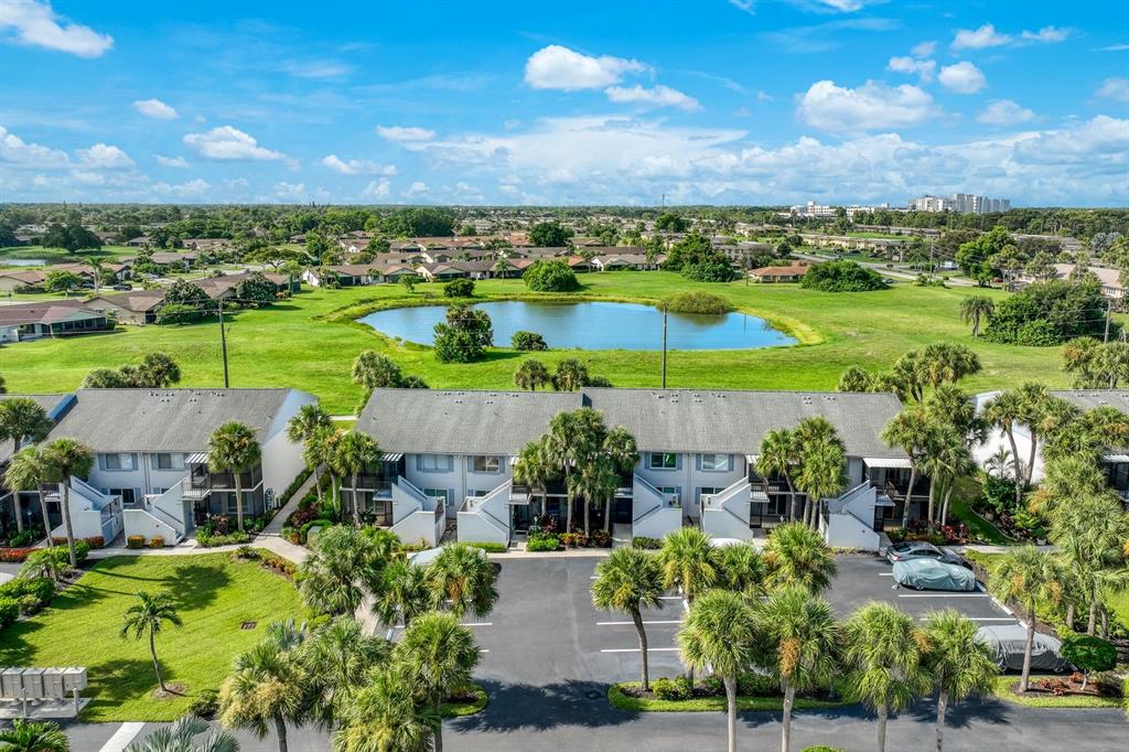 An aerial view of a large, irregularly shaped swimming pool surrounded by lounge chairs and palm trees — 4038 NORTHLIGHT DRIVE UNIT 1506, NAPLES, FL
