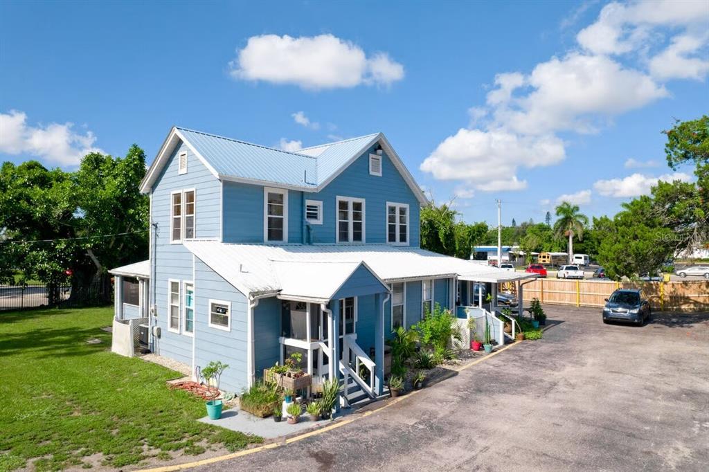 A two-story blue house with a metal roof and a paved parking lot — 1827 9TH STREET W, BRADENTON, FL