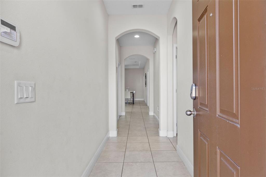 An open-concept living area features a kitchen island, dining table, and tile flooring — 194 AIDANS LANDING, HAINES CITY, FL