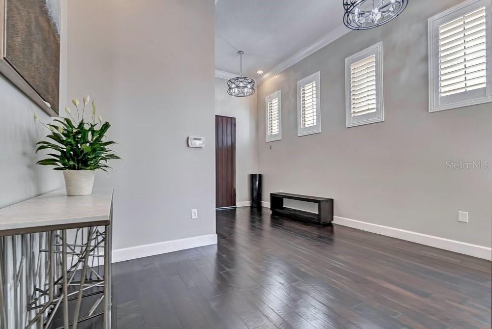 A kitchen with a white island, wooden ceiling beams, and a glass-enclosed wine display — 8449 VIA VITTORIA WAY, ORLANDO, FL