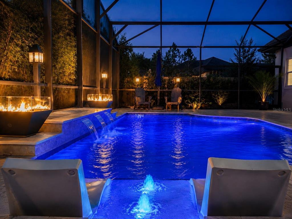A swimming pool with water features and a fire pit inside a screened-in patio area — 3336 LONE CYPRESS POINT, OVIEDO, FL