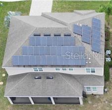 An aerial view shows a house roof with multiple solar panels installed — 17419 BELLA NOVA DRIVE, ORLANDO, FL