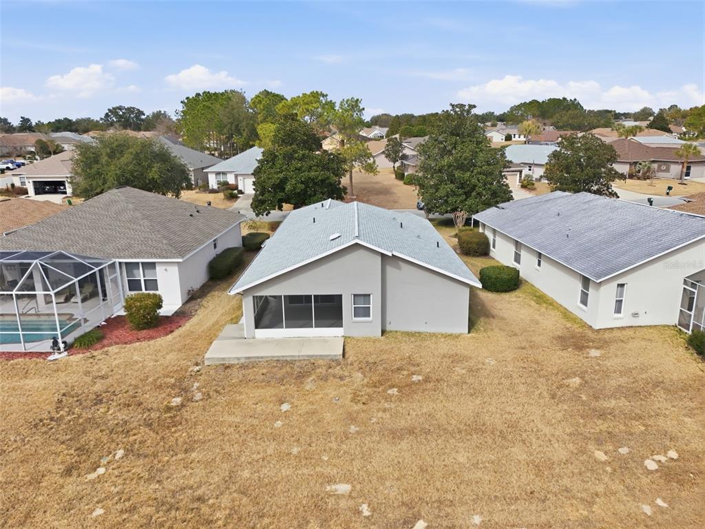 An aerial view shows the back of a gray house with a screened-in patio — 2311 N ANDREA POINT, LECANTO, FL