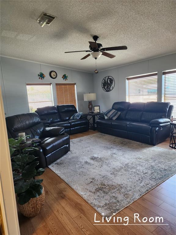 A living room features dark leather furniture, a large area rug, and wood-look flooring — 1001 STARKEY ROAD UNIT 758, LARGO, FL