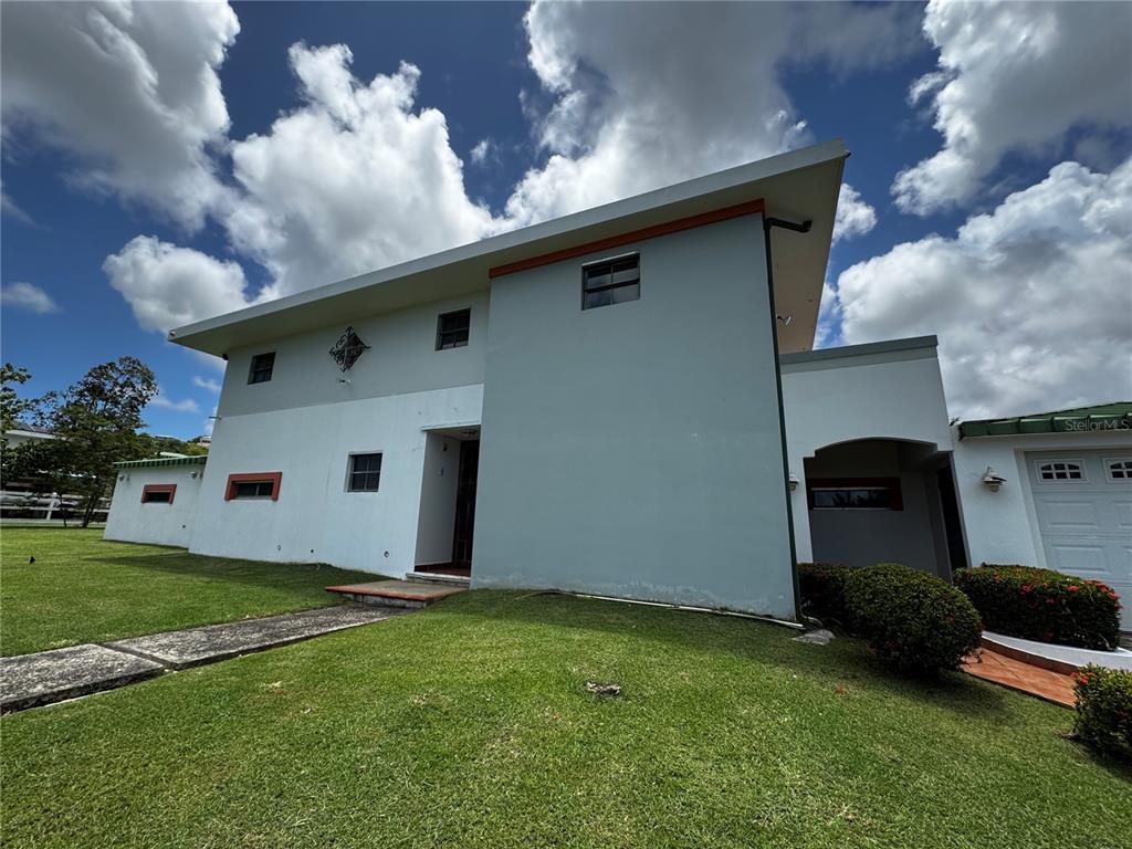 A two-story house with a light blue exterior, a white lower section, and a lawn — Ave. Hacienda Margarita URB. HACIENDA MARGARITA UNIT 8, LUQUILLO, PR