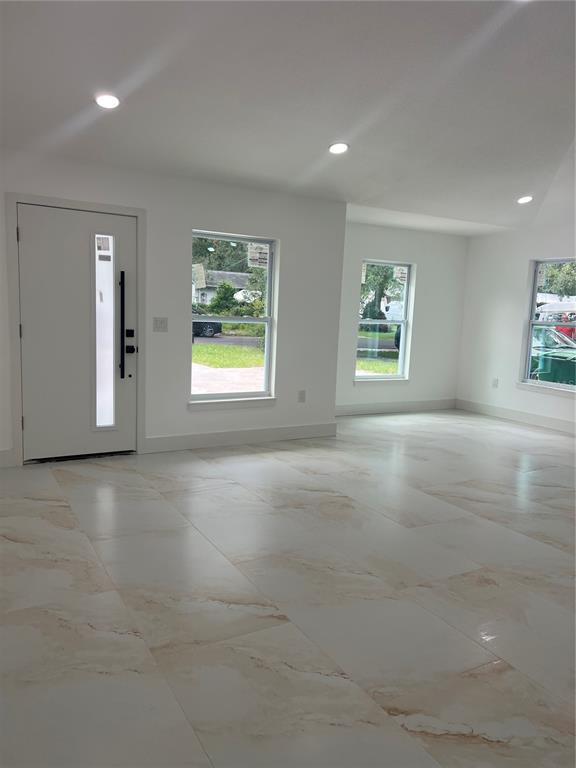 A bright living area features white walls, recessed lighting, and large marble-patterned floor tiles — 8915 N WILLOW AVENUE, TAMPA, FL
