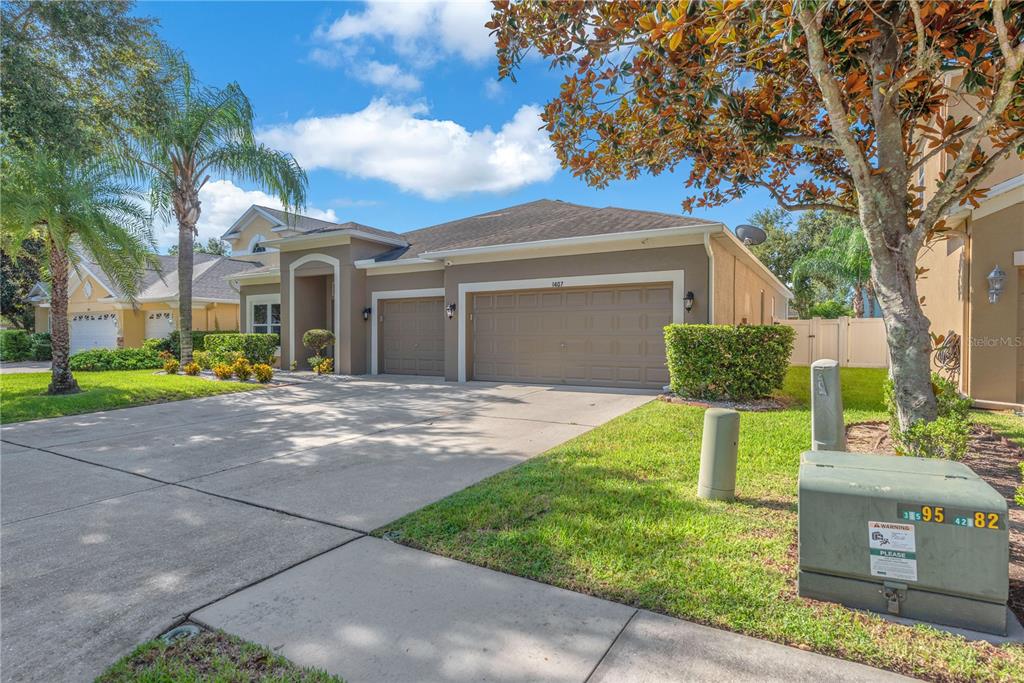 A single-story suburban house with a two-car garage and a concrete driveway — 1407 RUSHGROVE CIRCLE, DOVER, FL