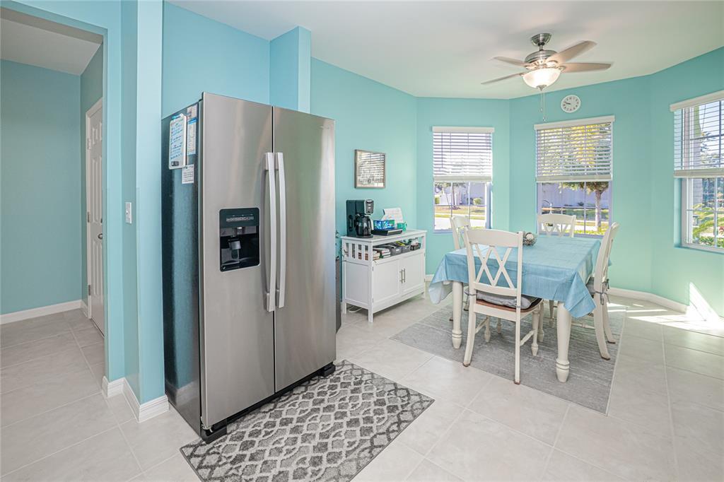 A dining area with light blue walls, a stainless steel refrigerator, and a white table — 25292 E LENOX CIRCLE, PUNTA GORDA, FL