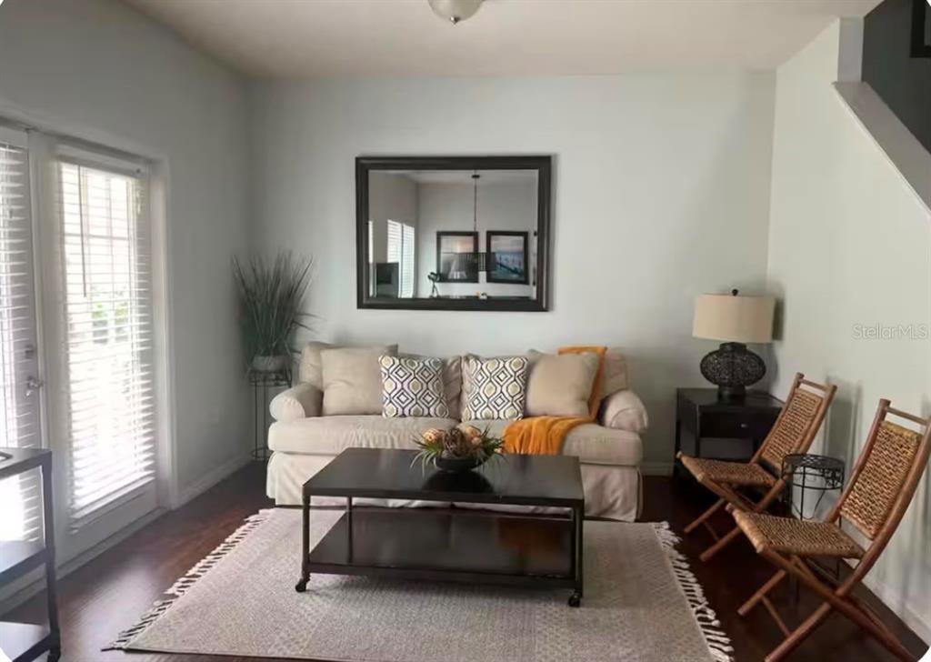 A living room features a beige sofa, a dark coffee table, and two wooden chairs — 5364 DIPLOMAT COURT UNIT 108, KISSIMMEE, FL