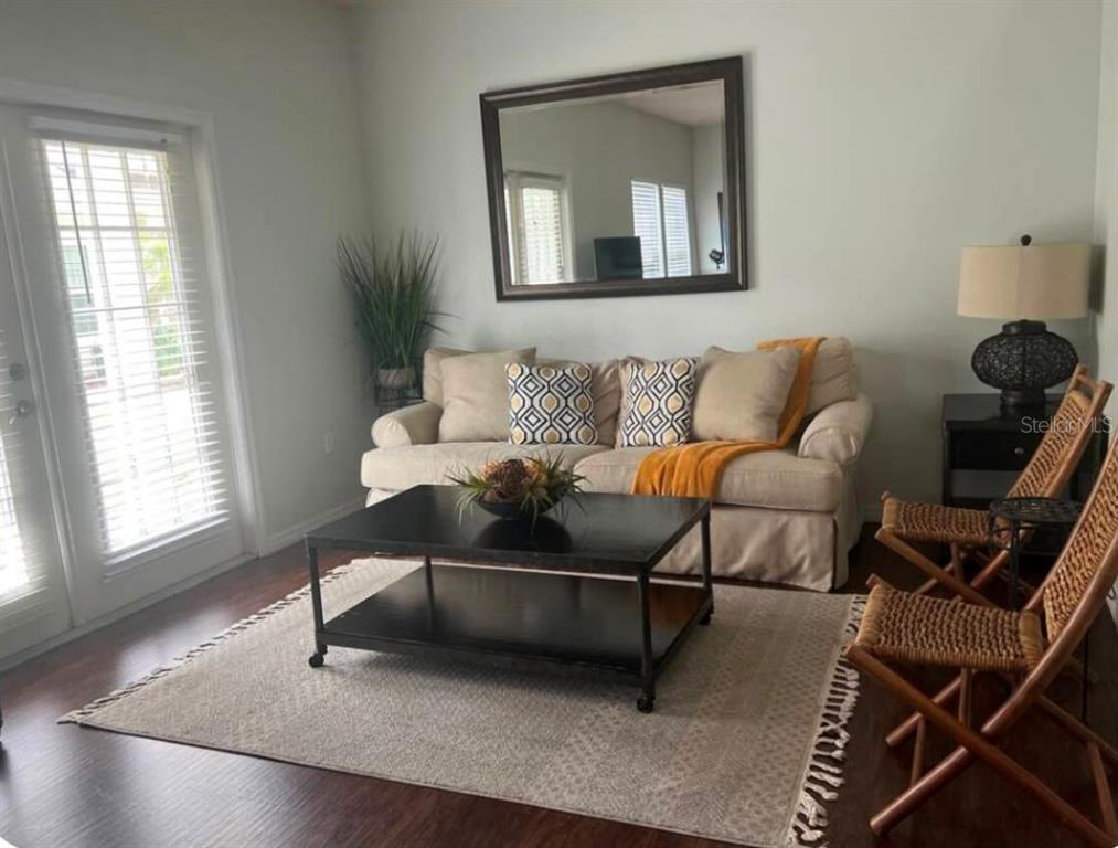 A living room features a beige sofa, a black coffee table, and two woven chairs — 5364 DIPLOMAT COURT UNIT 108, KISSIMMEE, FL
