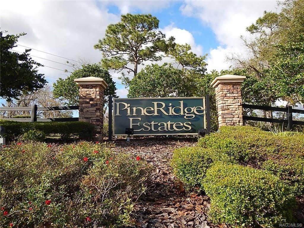 A stone monument sign for PineRidge Estates stands in front of trees and landscaping — 4976 W YEARLING DRIVE, BEVERLY HILLS, FL
