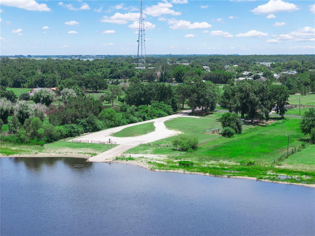 An aerial view shows a boat ramp leading into a lake near a grassy lot — 735 KEEN ROAD, FROSTPROOF, FL