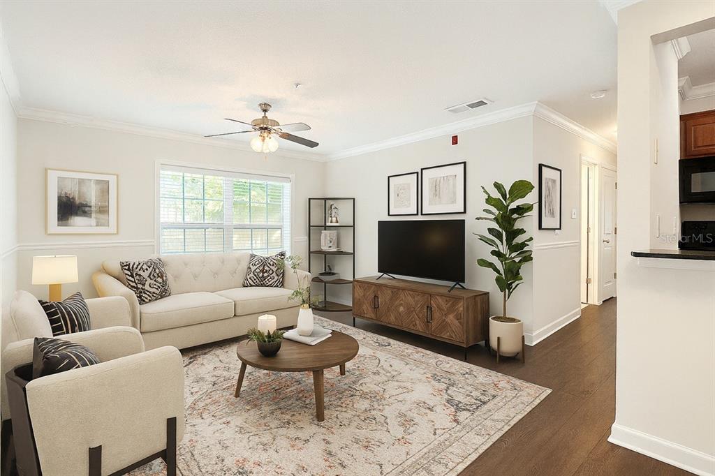 A living room features a beige sofa, two armchairs, a wooden coffee table, and television — 2059 DIXIE BELLE DR UNIT 2059n, ORLANDO, FL