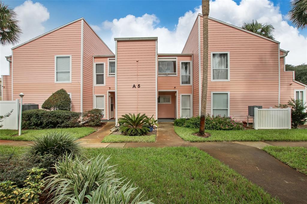 A two-story pink apartment building with a central entrance labeled A 5 and landscaping — 6300 S A1A UNIT A5 1U, ST AUGUSTINE, FL
