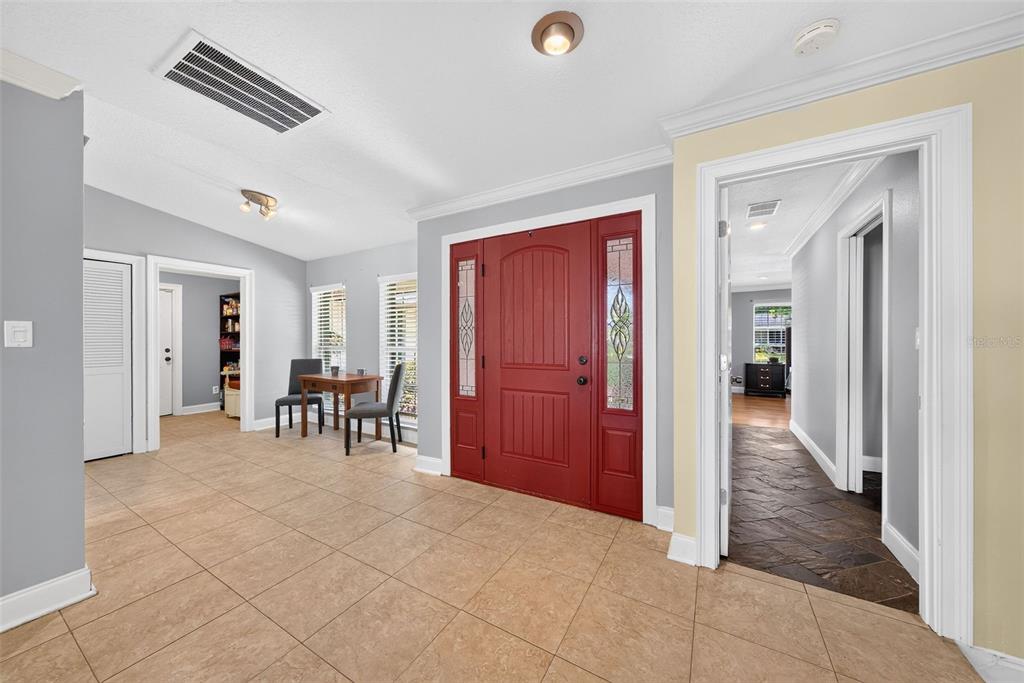 An entryway features a red front door, light tile flooring, and a view into hallways — 943 FAIRWAY DRIVE, WINTER PARK, FL