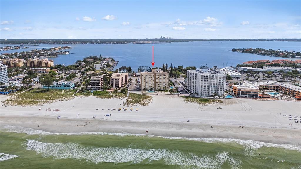 An outdoor swimming pool sits on a patio next to a beachside apartment building — 5000 GULF BOULEVARD UNIT 304, ST PETE BEACH, FL