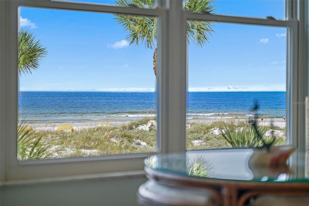 An aerial view shows a multi-story beachfront condominium building with a pool and parking lot — 5000 GULF BOULEVARD UNIT 304, ST PETE BEACH, FL