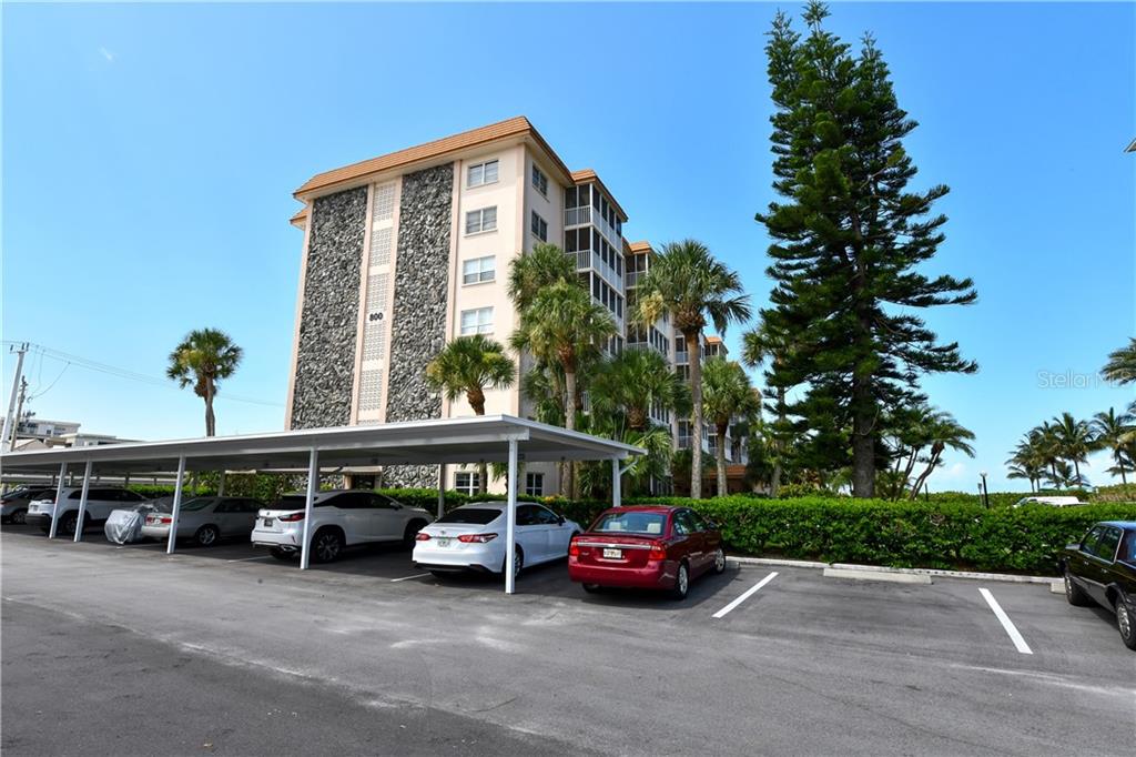 A multi-story apartment building with a covered parking area in the foreground — 800 BENJAMIN FRANKLIN DRIVE UNIT 403, SARASOTA, FL