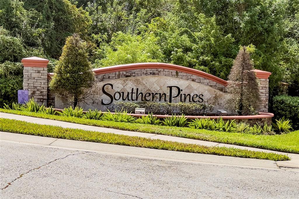 A stone monument sign for Southern Pines stands in front of trees and a sidewalk — 5590 SILVER THISTLE LANE, ST CLOUD, FL