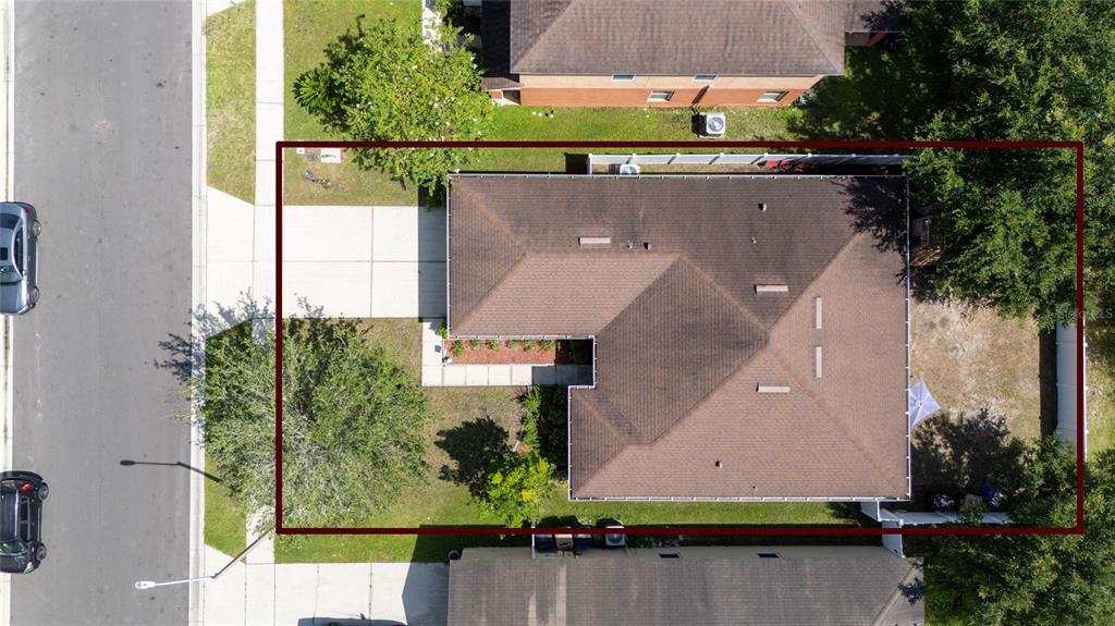 An aerial view shows a residential house with a brown roof and a paved driveway — 5590 SILVER THISTLE LANE, ST CLOUD, FL