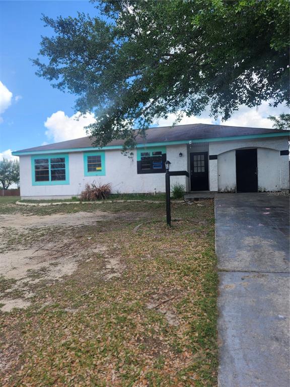 A single-story house with white stucco walls, turquoise trim, and a concrete driveway — 46 PALM ROAD, OCALA, FL