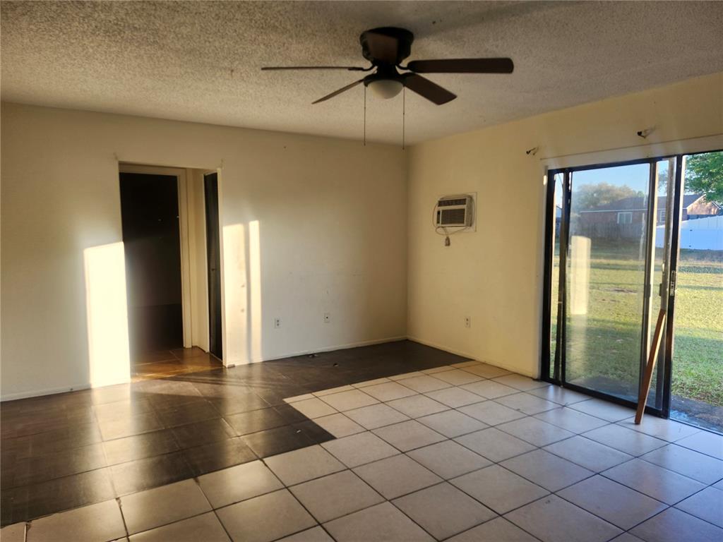 A living room with tile flooring, a ceiling fan, and sliding glass doors to outside — 46 PALM ROAD, OCALA, FL
