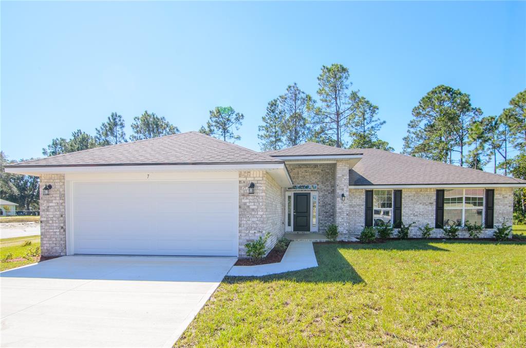 A single-story brick house with a two-car garage and a front walkway — 79 SLUMBER MEADOW TRAIL, PALM COAST, FL