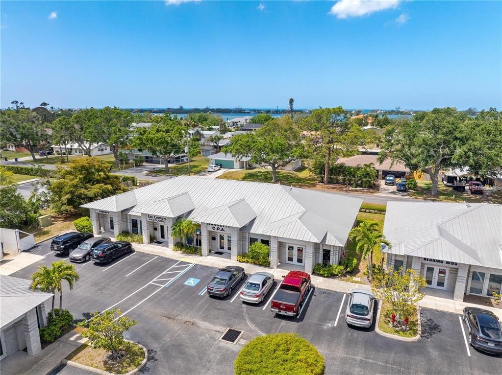 An aerial view shows a commercial office building with a parking lot and surrounding trees — 436 S TAMIAMI TRAIL UNIT C4, OSPREY, FL
