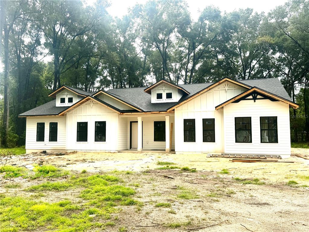 A newly constructed white farmhouse-style home with black window frames and a dark shingled roof — 23161 NW 183RD LANE, HIGH SPRINGS, FL