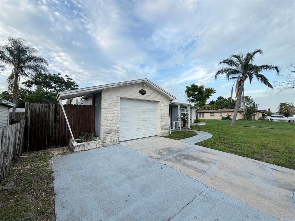 A single-story house with a white brick facade, a one-car garage, and a concrete driveway — 3221 ROXBURY DRIVE, HOLIDAY, FL