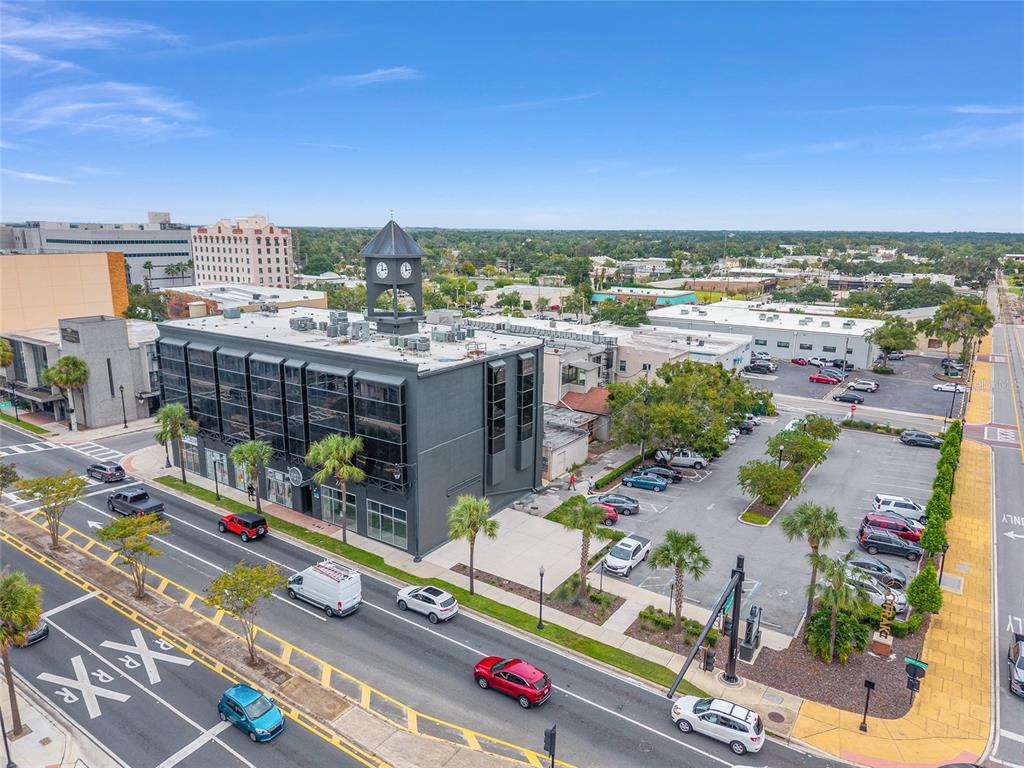 An aerial view shows a dark gray commercial building with a clock tower and parking — 101 SILVER SPRINGS BOULEVARD UNIT 400, OCALA, FL