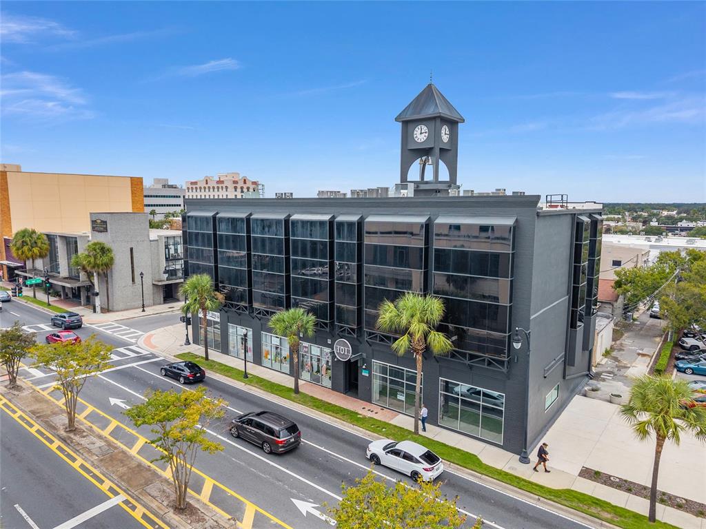 An aerial view shows a dark gray multi-story commercial building with a prominent clock tower — 101 SILVER SPRINGS BOULEVARD UNIT 400, OCALA, FL