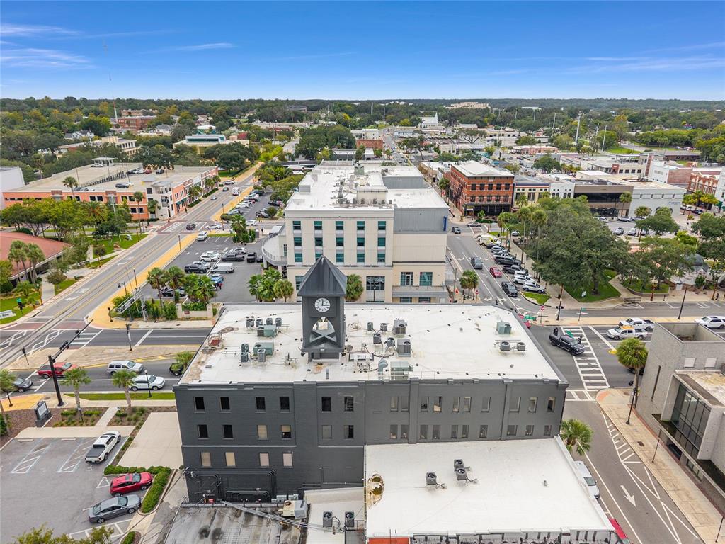 An aerial view shows a dark gray building with a clock tower in a city — 101 SILVER SPRINGS BOULEVARD UNIT 400, OCALA, FL