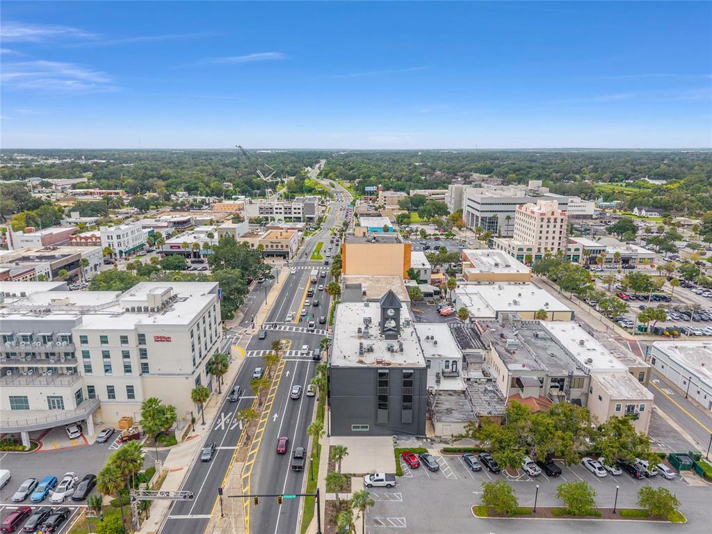 An aerial view shows a city street lined with commercial buildings, parking lots, and trees — 101 SILVER SPRINGS BOULEVARD UNIT 400, OCALA, FL