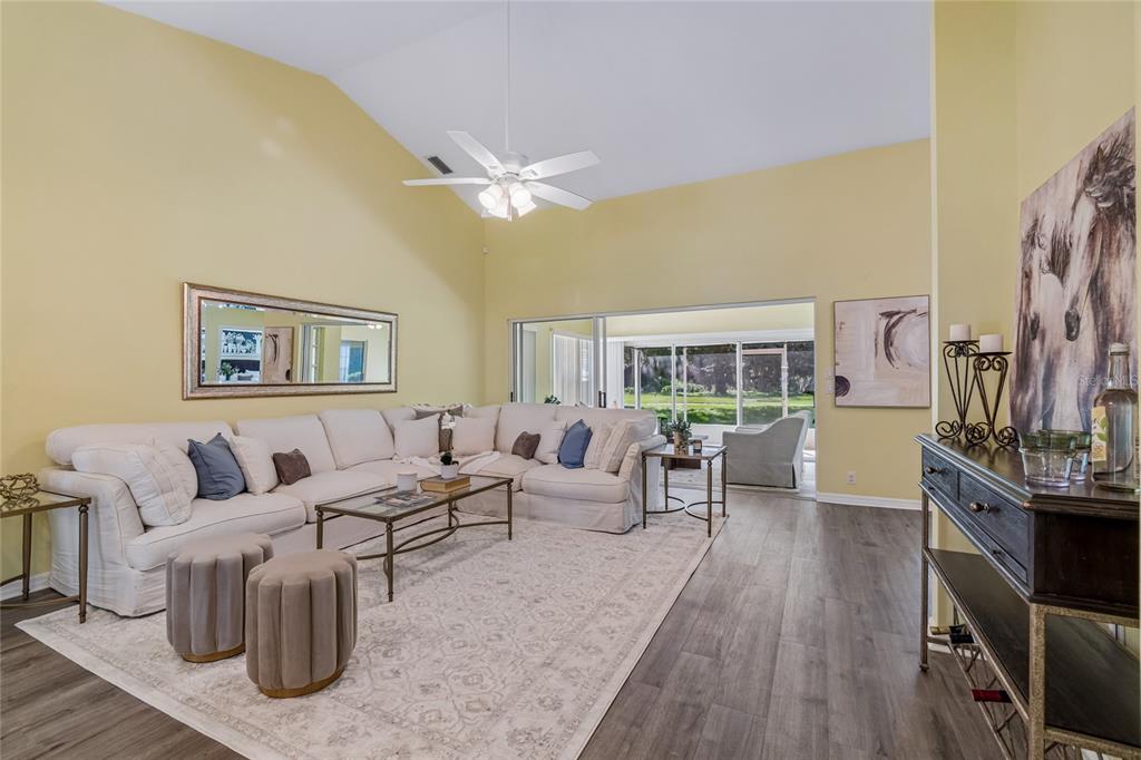 A yellow single-story house with a two-car garage and a large oak tree in front — 12728 FLAMINGO PARKWAY, SPRING HILL, FL