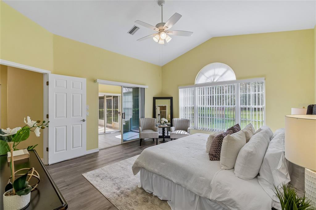 An entryway features a white front door with a sidelight, light yellow walls, and wood-look flooring — 12728 FLAMINGO PARKWAY, SPRING HILL, FL
