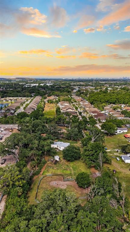 An aerial view shows a residential neighborhood with houses, trees, and open land at sunset — 5614 WATSON ROAD, RIVERVIEW, FL