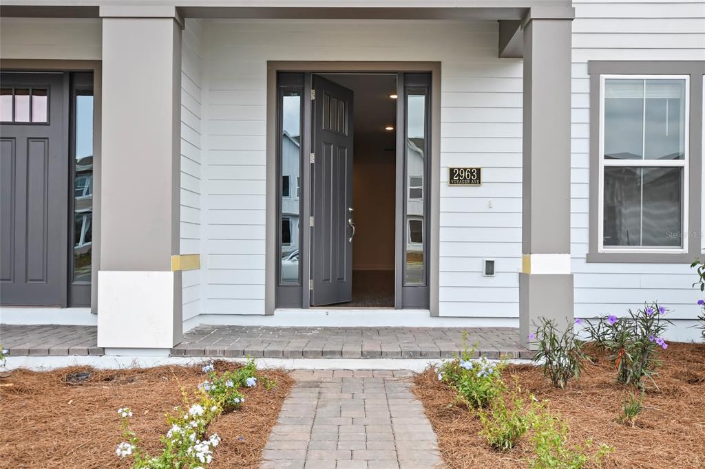 A front porch with a paved walkway leads to a dark gray front door — 2963 VOYAGER AVENUE, ST CLOUD, FL